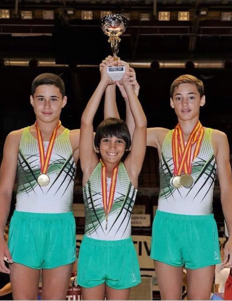 Alejandro de niño en el podio con su equipo y un trofeo