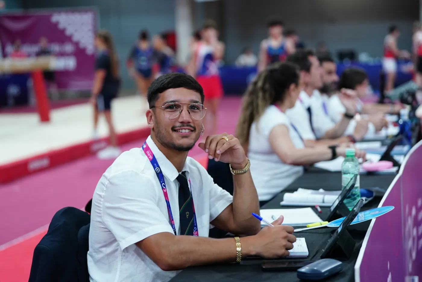 Alejandro sonriendo en la mesa de jueces durante una competición